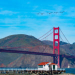 Pelicans flying by the Golden Gate Bridge